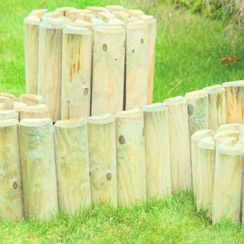 A close-up view of KDM's Log Edging Rolls- Variety of Heights showcases the rounded, light-colored wooden logs arranged in a row on green grass, ideal for decorative edging in landscaping or garden borders. These evenly cut logs offer both charm and practicality to beautifully enhance your outdoor space.