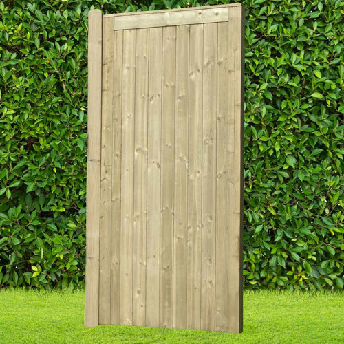 The Elite Tongue & Groove Euro-Gate - ETG180 by KDM stands tall before a lush green hedge, its vertically arranged wooden planks crafted in a Tongue & Groove style, offering both sturdiness and elegance above a neatly trimmed grassy lawn.