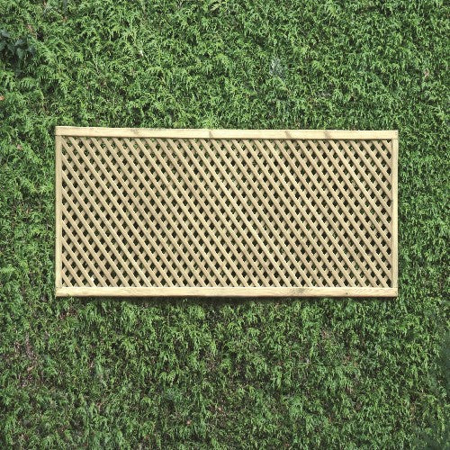 Load image into Gallery viewer, A KDM Trellis - Privacy Lattice - Rectangle 60cm x 183cm (PL9) is mounted on a lush hedge, contrasting the structured crisscross diamond pattern with the organic, textured leaves.
