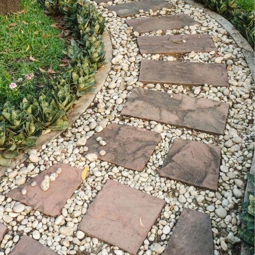 Load image into Gallery viewer, curved garden path with flower beds to either side and stone flags embedded with gravel and pebbles
