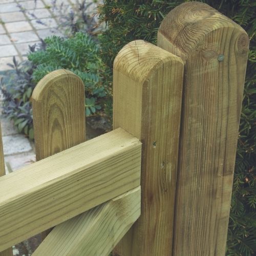 close of picket gate with rounded fence posts and palings